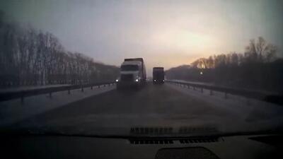 عبور هولناک یک خودرو از بین دو تریلی (فیلم)