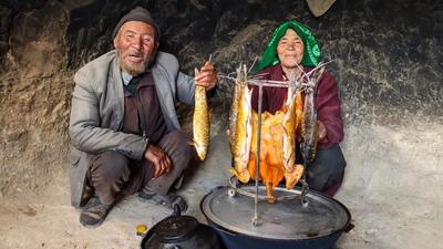 کباب کردن ماهی و مرغ در تنور زیرزمینی توسط زوج افغان (فیلم)