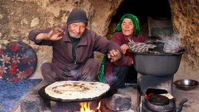 (ویدئو) روش دیدنی پخت نان ساجی و املت زغالی توسط یک زوج جوان غارنشین افغان
