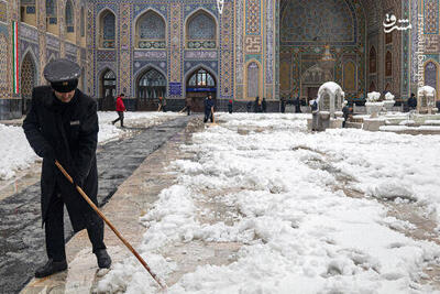 فیلم/ برف روبی خادمان رضوی زیر بارش برف