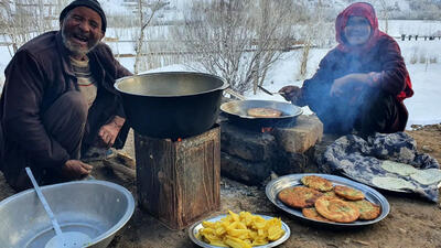 (ویدئو) فرآیند دیدنی پخت نان سبزیجات و سیب زمینی توسط زوج مسن غارنشین افغان