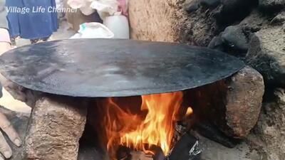 (ویدئو) نحوه پخت نان ساجی و کباب کردن مرغ به سبک جالب یک زوج غارنشین افغان
