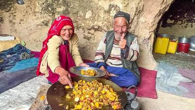 (ویدئو) نمایی از پخت غذا با سیب زمینی، گوجه و بادمجان توسط یک زوج غارنشین افغان