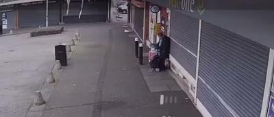 حادثه برای زن سالخورده هنگام بالارفتن کرکره فروشگاه (فیلم)