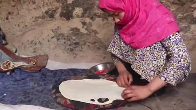 (ویدئو) روش دیدنی یک خانواده غارنشین افغان در پخت نان روی ساج و کوکوی سنتی