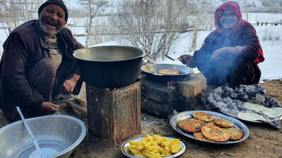 (ویدئو) پخت یک غذای سنتی با سیب زمینی و آرد به سبک زوج مسن غارنشین افغان