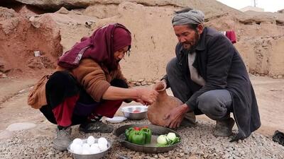 (ویدئو) نحوه پخت نان و غذا با تخم مرغ، دلمه و گوجه توسط یک زوج غارنشین افغان