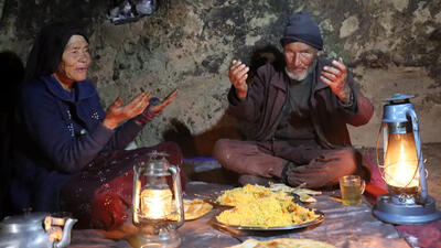 (ویدئو) پخت پلو مرغ محلی در یک غار باستانی توسط یک زوج مسن افغان