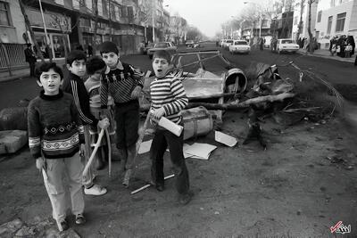 عکس/ کودکان و خیابانی با خودروی سوخته در روز‌های انقلاب