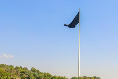 عکس | برافراشته شدن پرچم عزا در بزرگ‌ترین برج پرچم کشور در اراضی عباس‌آباد - عصر خبر