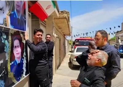 تصویری غم انگیز از پدر شهید خلبان «محسن دریانوش» هنگام دیدن بنر نصب شده پسرش روی دیوار منزل
