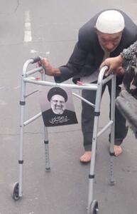 عکس | قابی تاثیربرانگیز از پیرمردی با واکر و عکس رئیسی در مراسم تشییع امروز تهران - عصر خبر