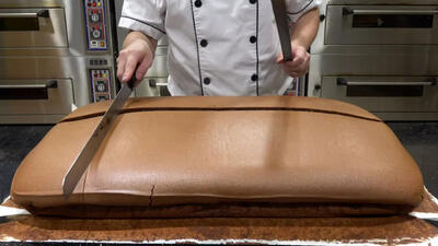 (ویدئو) مهارت درخشان قناد مالزیایی در برش زدن کیک بزرگ شکلاتی