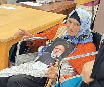 حضور بانوی مسن قزوینی با ویلچر و تصویر شهید رییسی در پای صندوق