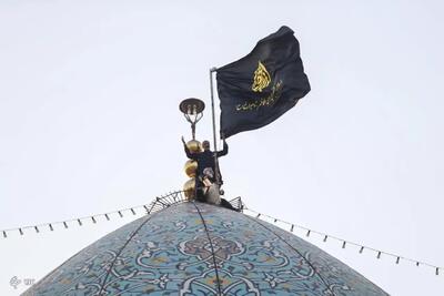 اهتزاز پرچم عزای حسینی بر فراز گنبد حرم شاهچراغ