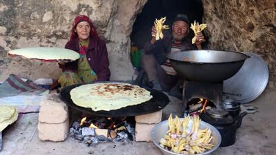 (ویدئو) پخت خورشت پای مرغ با سبزیجات توسط زوج غارنشین مسن افغان