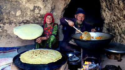 (ویدئو) پخت خوراک مرغ و نان محلی توسط زوج روستایی مسن افغان