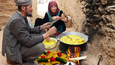 (ویدئو) پخت یک غذای محلی با سیب زمینی، آرد و تخم مرغ توسط زوج افغان