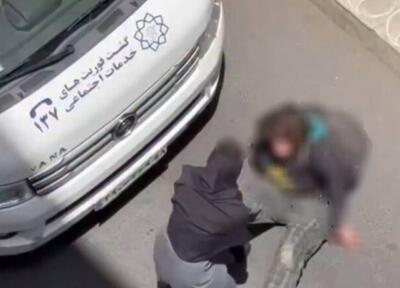 کشیدن یک زن توسط گشت فوریت‌های اجتماعی شهرداری تهران / شهرداری: فرد مذکور در پی سوء مصرف مواد مخدر، حالت طبیعی نداشت / یکی از اهالی، هیجان زده وارد عمل شد و زن میانسال را به داخل خودروی گشت منتقل کرد