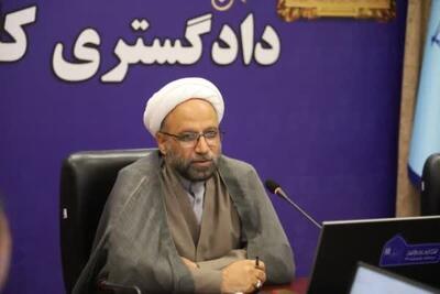 دادگاه علنی مقام قضایی را در یک اتاق شیشه‌ای قرار داده است
