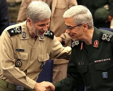 امیر حاتمی در حال نشانه‌گیری با مسلسل در کنار سپهبد باقری