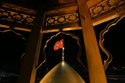 پرچم سرخ «یا حسین» بر فراز گنبد حرم بانوی کرامت به اهتزاز درآمد