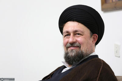 تصویر سیدحسن خمینی در کنار لباس نظامی سردار سلامی که در لحظه شهادت بر تن داشت