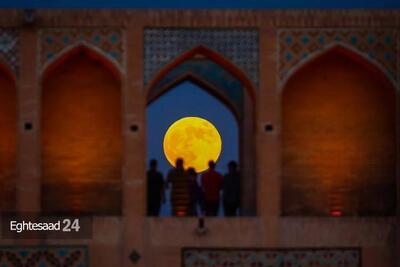 عکس/ منظره‌ای شگفت انگیز از طلوع ابرماه در میان دالان‌های پل خواجو | اقتصاد24