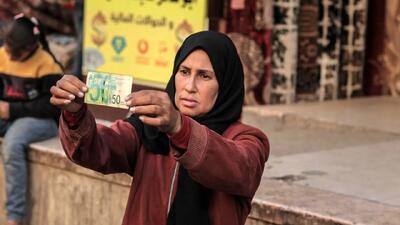  تصاویر؛ زن فلسطینی با ترمیم اسکناس‌های پاره امرار معاش می‌کند