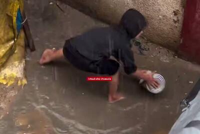  فیلم/ تلاش کودک فلسطینی برای تخلیه آب باران از چادر در غزه