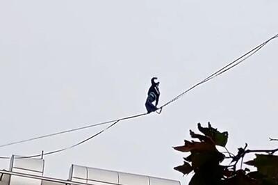 حرکت خطرناک دختر جوان روی سیم‌های معلق بین ساختمان