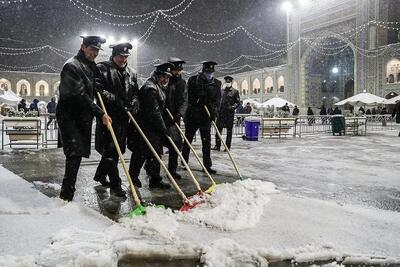 ببینید / برف‌روبی پشت‌بام حرم امام رضا(ع)