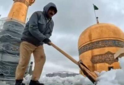 فیلم/ برف‌روبی پشت‌بام حرم امام رئوف