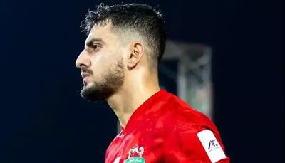 جوان ایرانی روی پوستر مقابل السد قطر