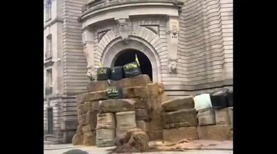 کشاورزان فرانسوی ساختمان‌های دولتی را با کاه مسدود کردند (فیلم)