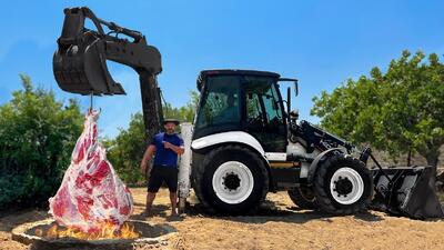 پخت ران غول‌پیکر گاو با تراکتور در تنور زیرزمینی (فیلم)