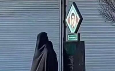 لحظه تاثر برانگیز یک مادر در خیابان مقابل تصویر فرزند شهیدش