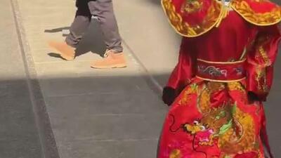  یک ربات با لباس خدای ثروت چینی که در شهر شانگهای این کشور دیده شده