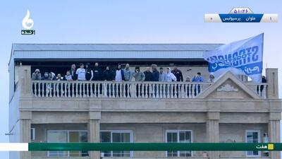  تماشاگران ملوانی از خانه ‌های اطراف در حال مشاهده مسابقه