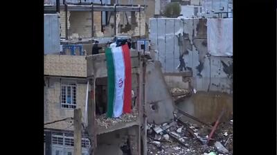  اهتزاز پرچم مقدس ایران در خانه‌ای که در خرم‌‌آباد موشک‌باران شد