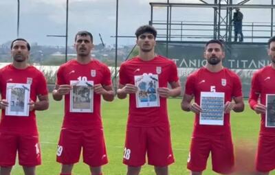  تصاویر شهدای ایرانی، شهدای ناو دنا، اماکن ورزشی و ابنیه تاریخی تخریب شده، نیرو‌های هلال احمر و آتش نشان در جنگ تحمیلی در دستان ملی پوشان و اعضای کادر تیم ملی پیش از دیدار برابر کاستاریکا