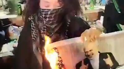  تصاویر آتش زدن عکس ظریف توسط یک دختر با شعار مرگ بر سازشگر