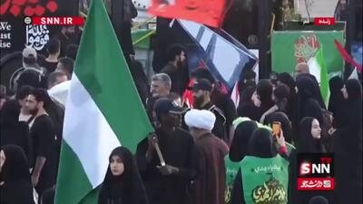  حضور زائری با پرچم نیجریه در مسجد جمکران برای اقامه نماز بر رهبر شهید انقلاب