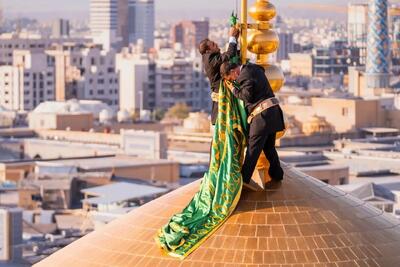  تعویض پرچم گنبد حرم امام رضا بعد از ۶٣ روز
