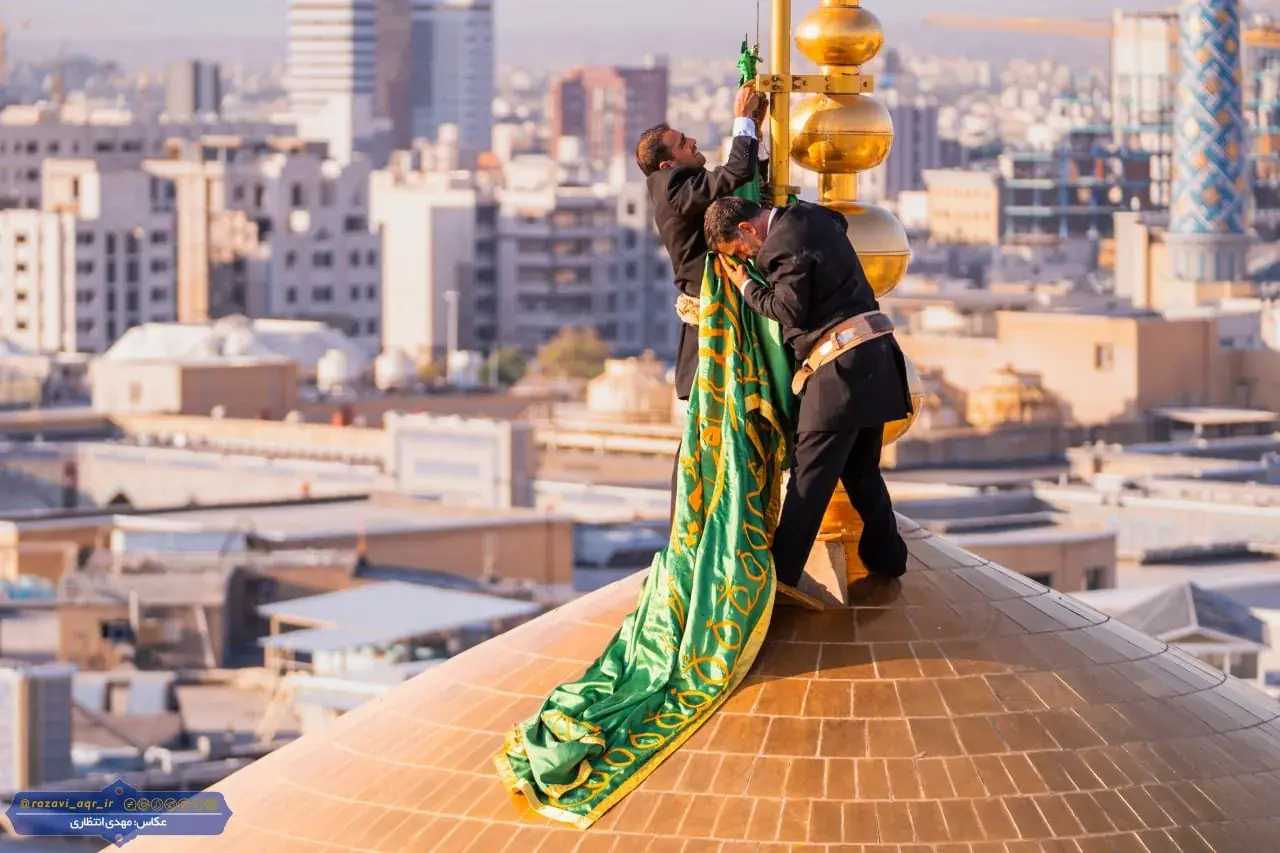 تعویض پرچم گنبد مطهر امام رضا (ع) بعد از ۶٣ روز