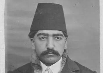 پسر ناصرالدینشاه نشسته روی زیرانداز در حیاط کاخ سلطنتآباد