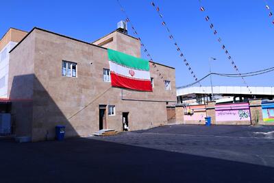 نصب پرچم بر سردر ۵۷ مدرسه شهیدپرور تهران